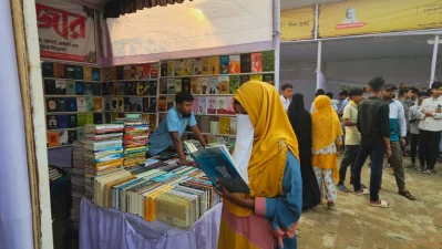 স্টলে বই দেখছেন এক শিক্ষার্থী/ঢাকা ট্রিবিউন