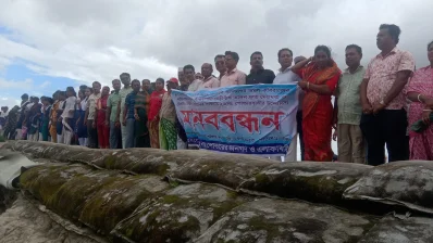 বাঁধের ওপর দাঁড়িয়ে মানববন্ধন করছেন স্থানীয়রা